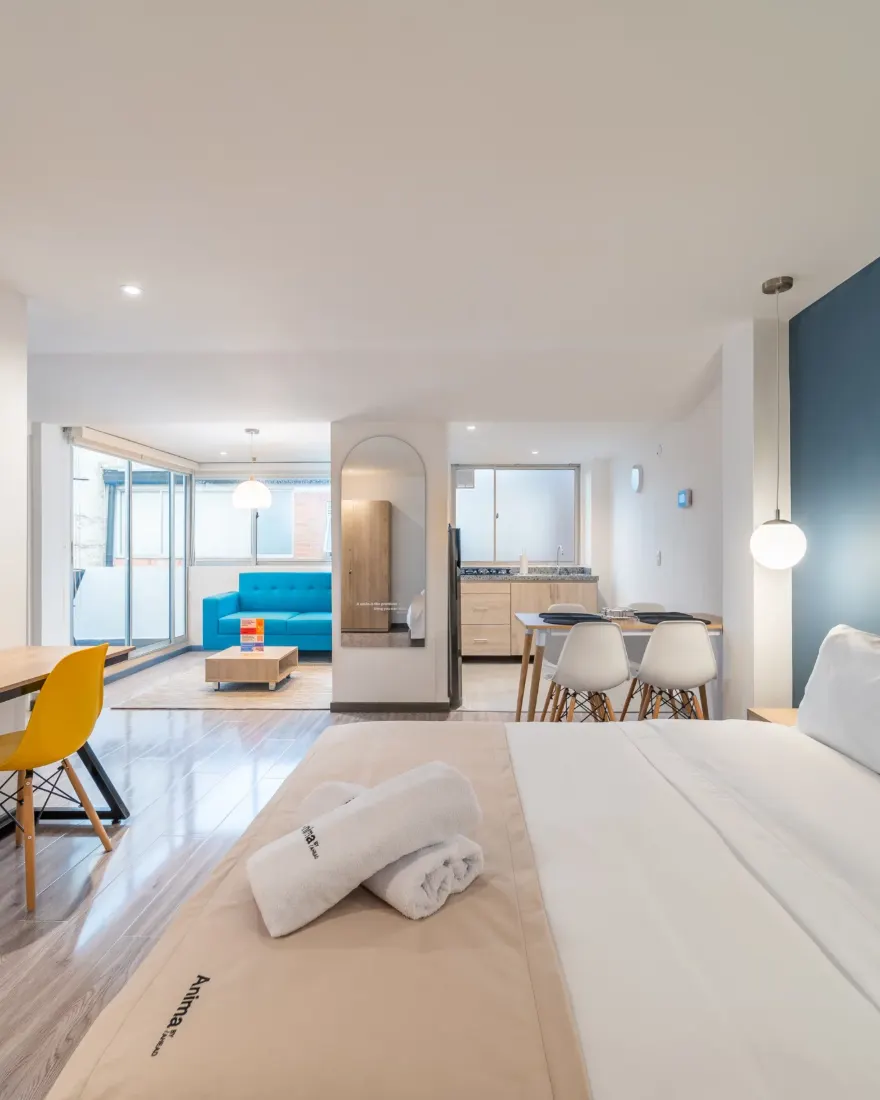 Habitación de Anima 64 con cama doble, escritorio y pared azul