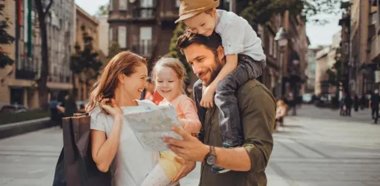 Familia de viaje mirando un mapa en una calle de la ciudad