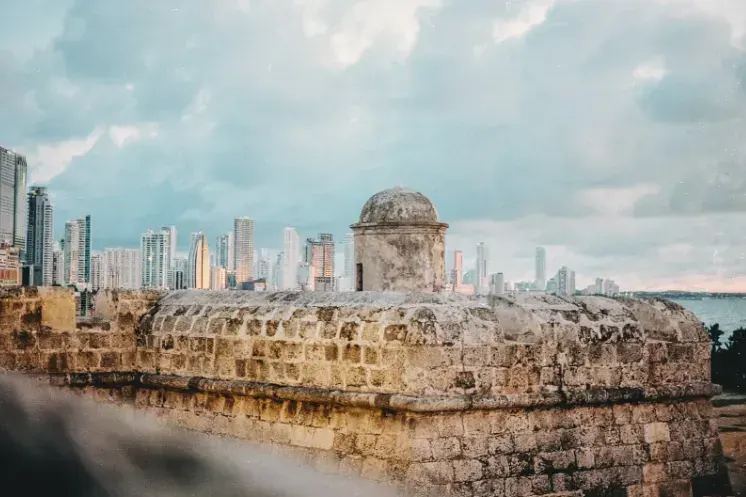 Murallas de piedra de Cartagena frente al mar con los edificios de Bocagrande al fondo