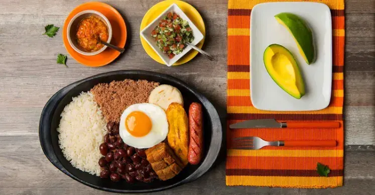 Bandeja paisa con fríjoles, arroz, huevo, chicharrón, aguacate y arepa